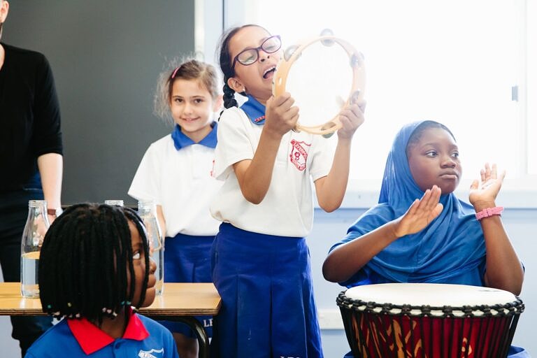 four primary school students enjoying an arts learning music education lesson on percussion instruments