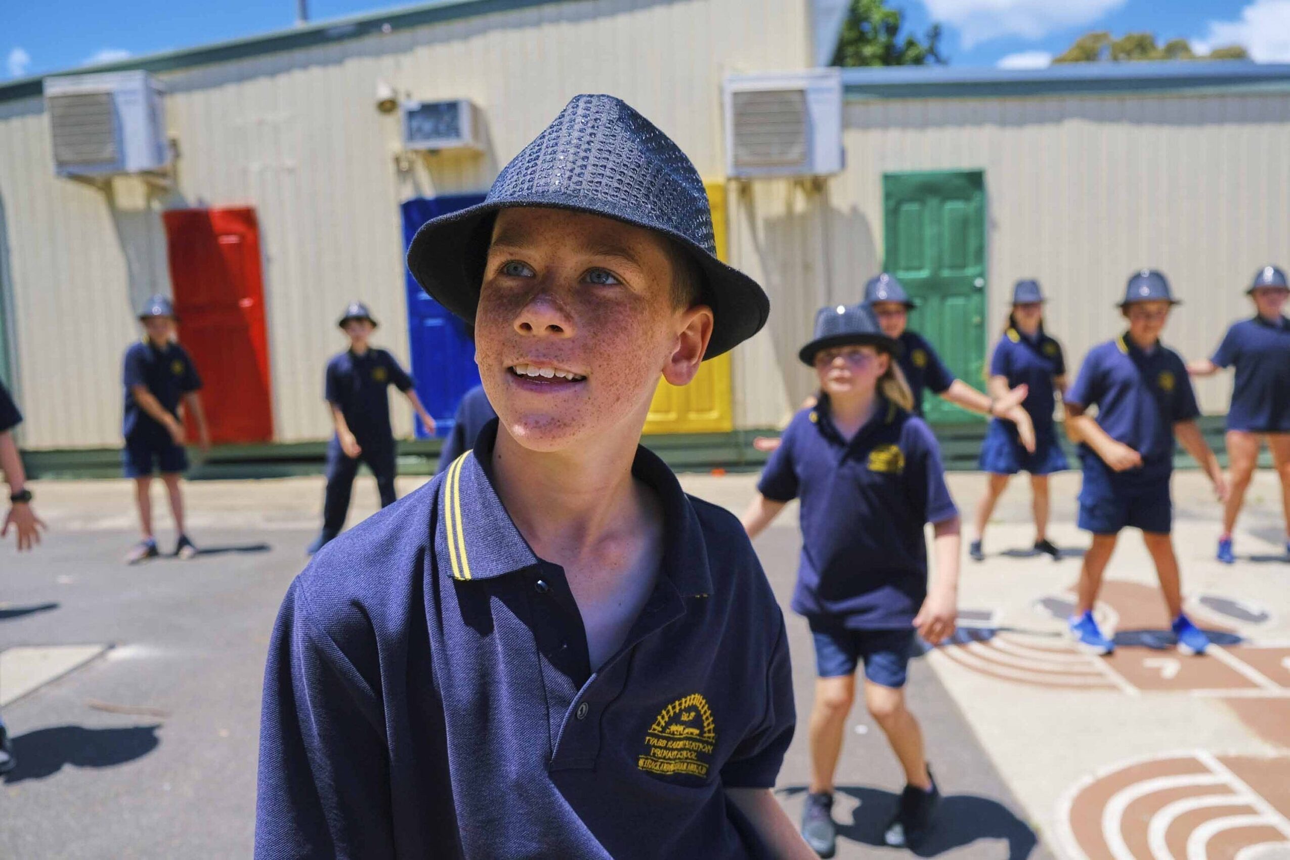 primary school students wearing navy hats enjoying outdoor movement class