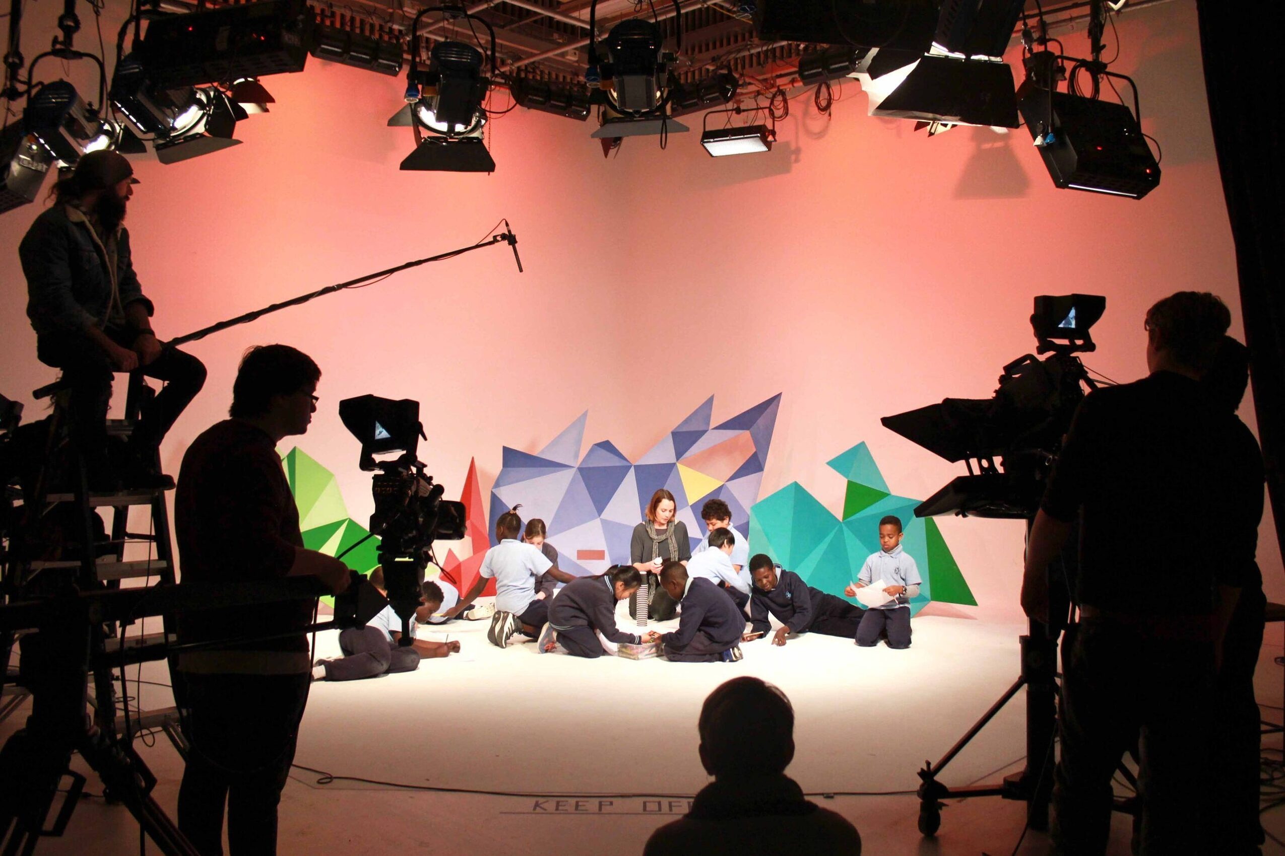 people working on a studio set creating online education resources featuring teacher and primary school students
