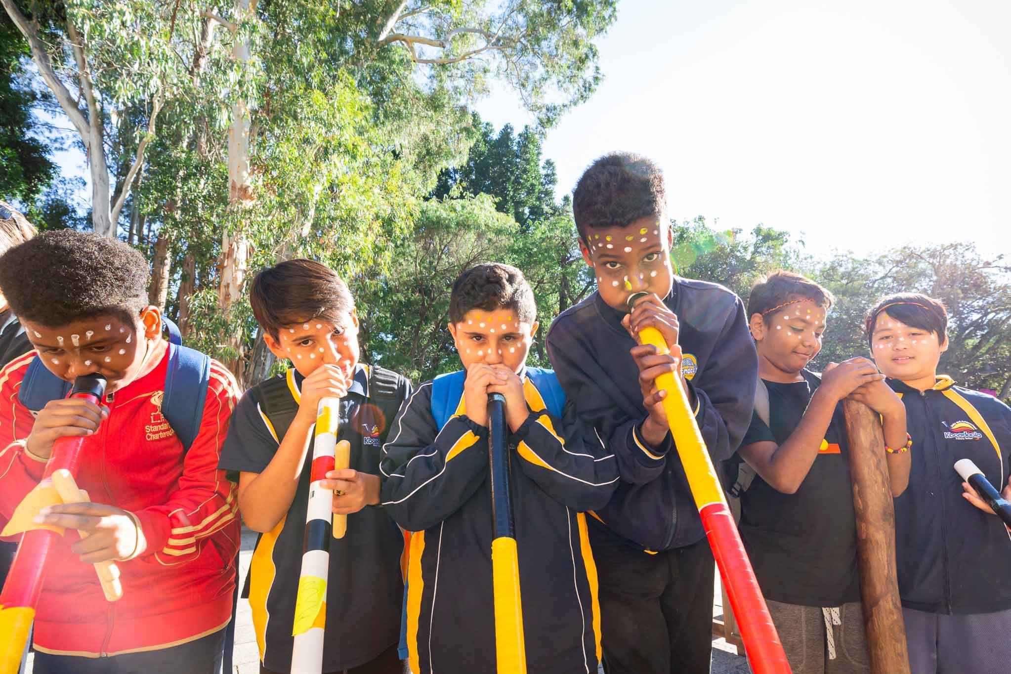 six primary school students engaged in an indigenous arts learning music lesson in didgeridoo