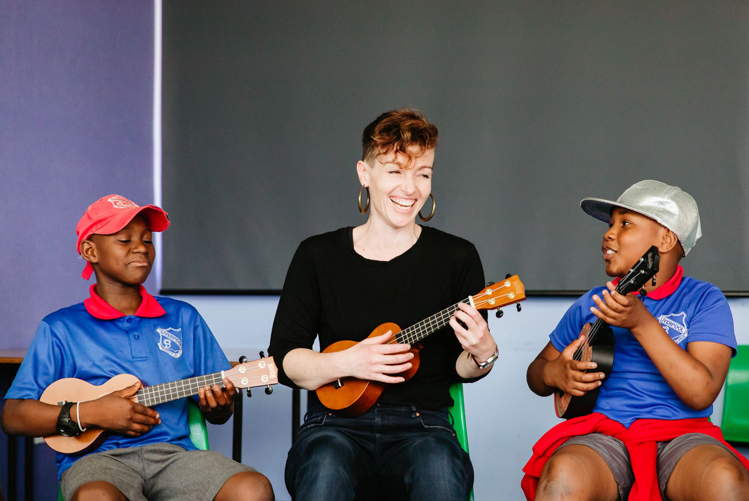 The Song Room Teaching Artist teaching two primary school students an arts learning music lesson in ukulele