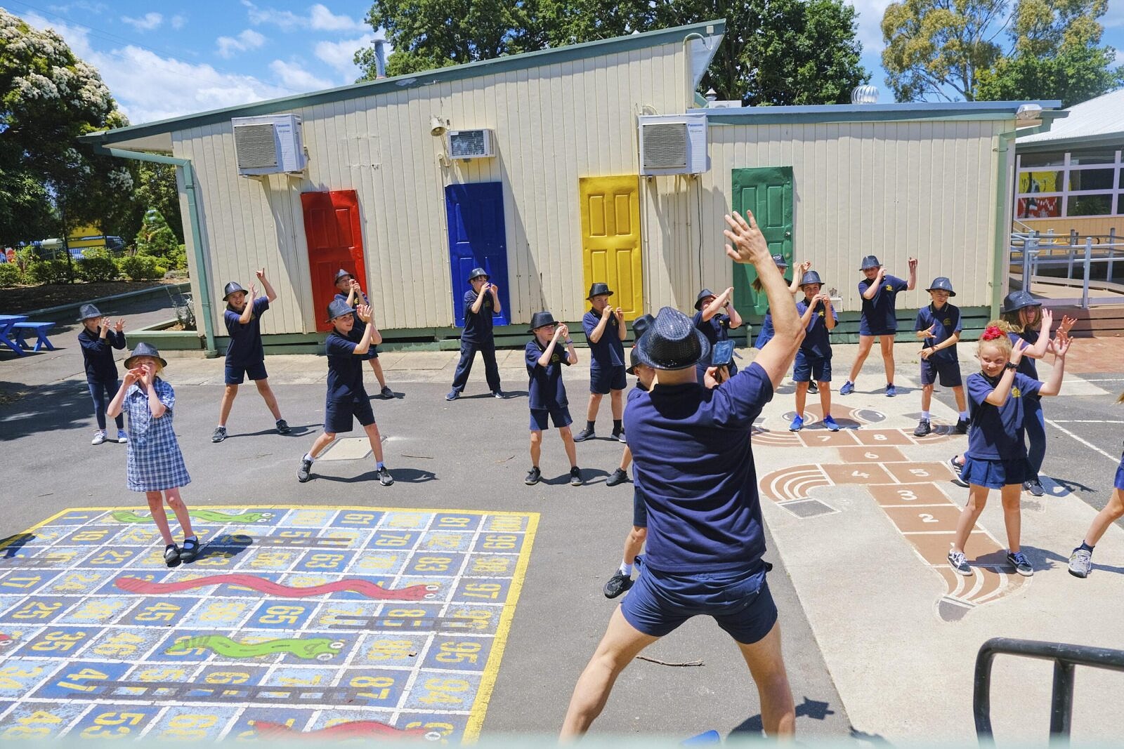 class of primary school students engaged in outdoor arts learning movement lesson