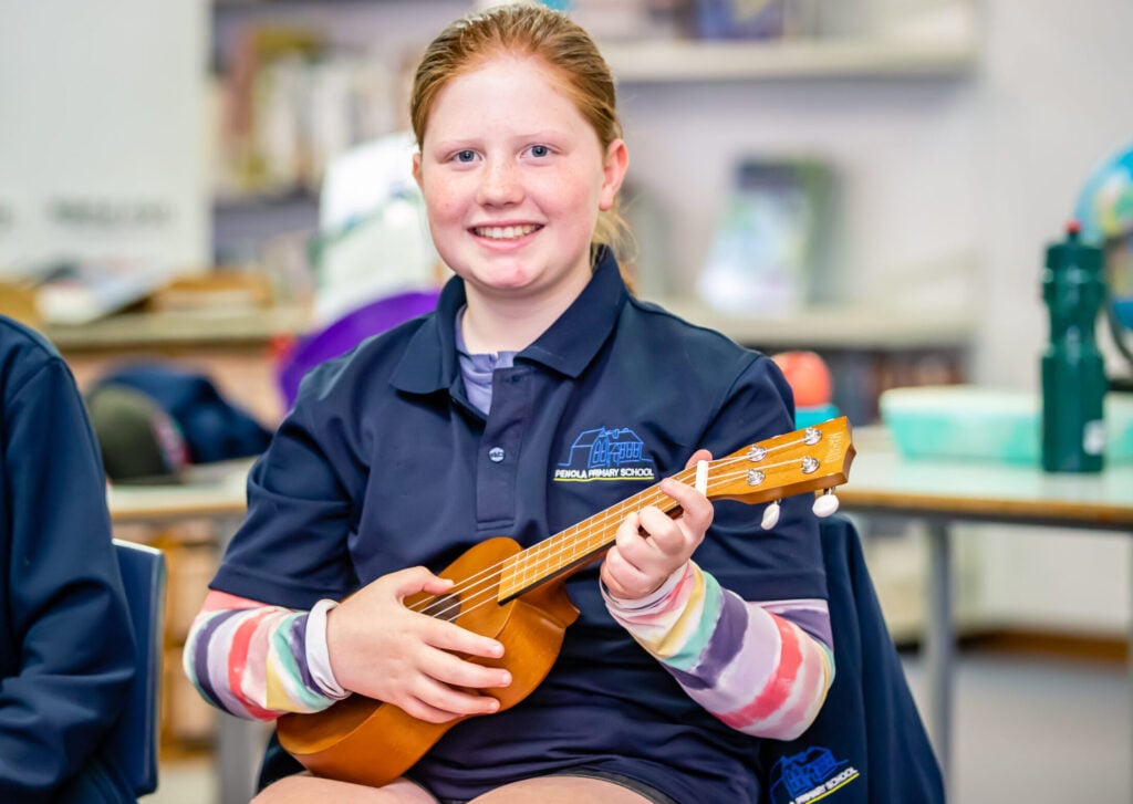 primary school student playing ukulele in arts learning music lesson