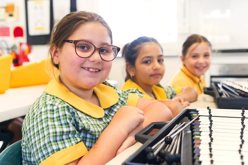 happy primary school students with xylophones