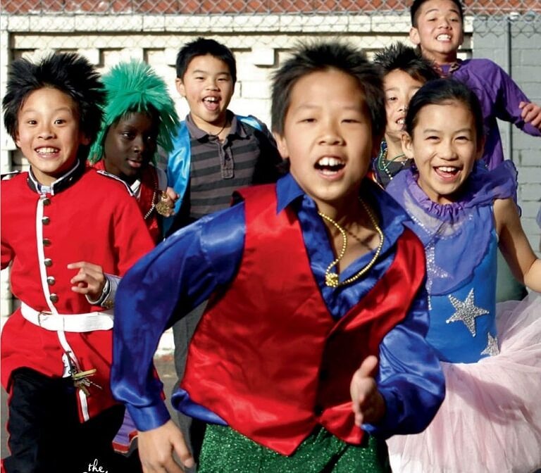 group of children in fancy dress run excitedly towards the camera