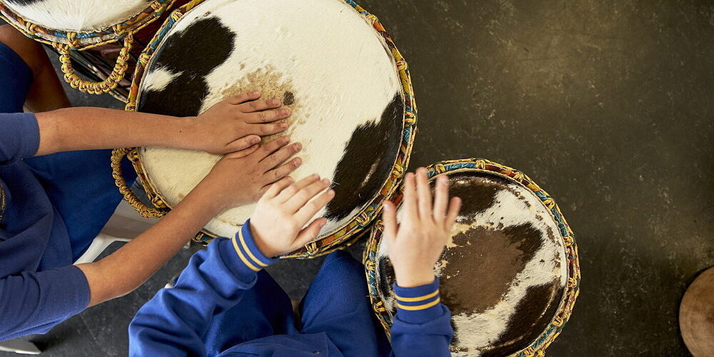 primary school student in an arts learning music lesson on African drums