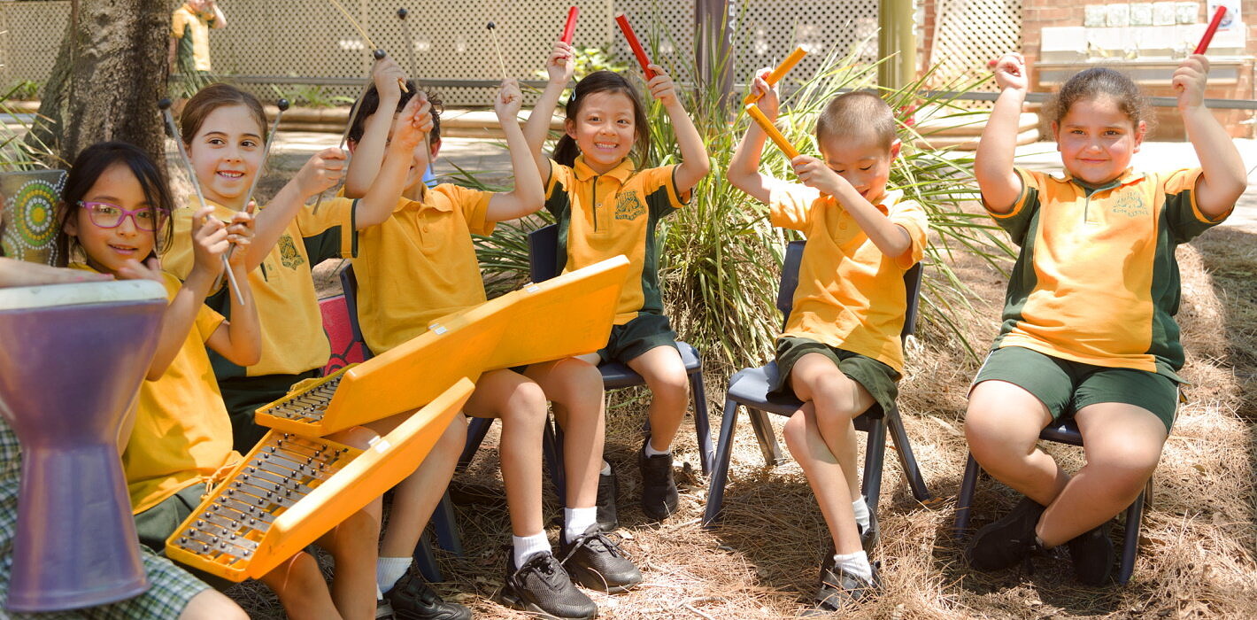 primary school students engaged in arts learning outdoor music class playing musical instruments